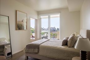 San Diego apartment for rent - A bedroom with a large bed and a view of the outside.