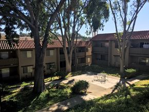 Vista apartment for rent - a courtyard with trees and a firepit at the whispering winds apartments in pearland, tx