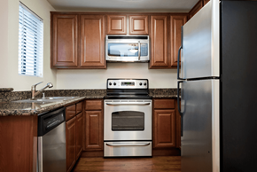 Oceanside apartment for rent - a kitchen with wood cabinets and stainless steel appliances