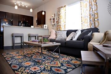 Denton apartment for rent - A living room with a black couch and a coffee table.