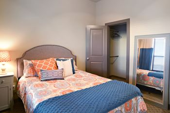 A bedroom with a bed and a closet and a mirror