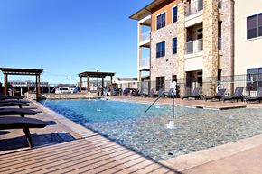Denton apartment for rent - a swimming pool with a building in the background at Urban Square, Denton, Texas