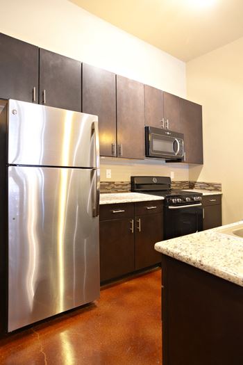 A kitchen with stainless steel appliances and black cabinets