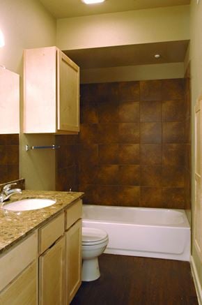 Denton apartment for rent - A bathroom with a brown tile wall and a white toilet at Centre Place Apartments, TX, 76205