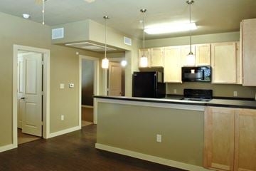 Denton apartment for rent - A kitchen with a black refrigerator and microwave.