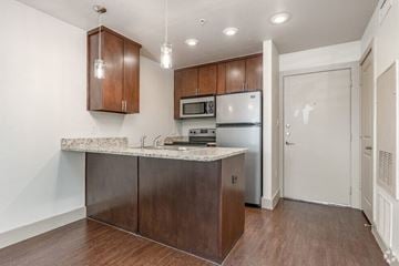 Denton apartment for rent - A kitchen with brown cabinets and a marble countertop.