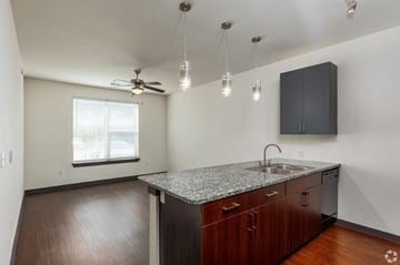 Denton apartment for rent - A kitchen with a granite countertop and wooden cabinets.