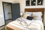 Denton apartment for rent - A bedroom with a bed, a wardrobe, and a wall-mounted shelf.