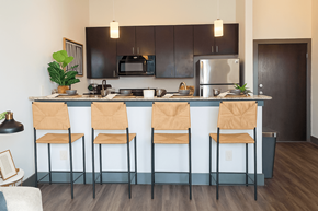 Denton apartment for rent - A kitchen with black cabinets and a blue island.