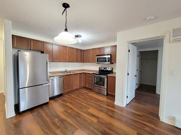 Kingston apartment for rent - A kitchen with wooden cabinets and a stainless steel refrigerator.