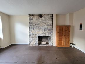 Kingston apartment for rent - A room with a stone fireplace and a wooden door.