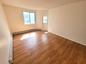 Kingston apartment for rent - an empty living room with wood floors and a window