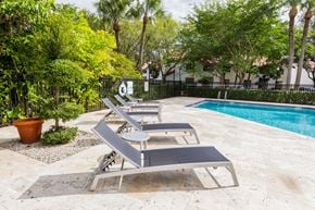 Coral Springs apartment for rent - a group of lounge chairs sitting next to a swimming pool