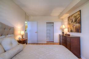 Kingston apartment for rent - A bedroom with a large bed, a dresser, and a painting on the wall.