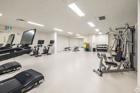 Kingston apartment for rent - a gym with cardio equipment and weights in a large room