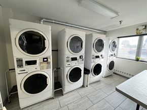 Kingston apartment for rent - A row of white front load washing machines in a laundromat.