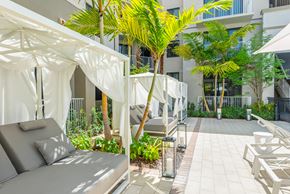 Tamarac apartment for rent - a patio with chairs and umbrellas and palm trees