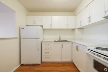 Kingston apartment for rent - A white refrigerator and oven in a kitchen with wooden floors.