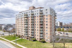 Kingston apartment for rent - A large apartment building with a parking lot in front.