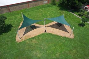 Houston apartment for rent - A green and brown shade structure in a grassy area.