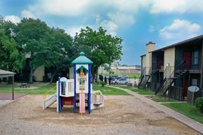 Houston apartment for rent - A playground with a slide and a playhouse.