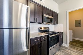 Tomball apartment for rent - a kitchen with stainless steel appliances and wooden cabinets