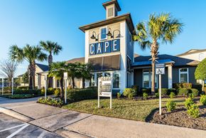 Tomball apartment for rent - a building with a sign that says cape in front of palm trees