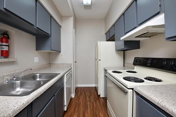 Houston apartment for rent - A kitchen with a white stove and a white refrigerator.