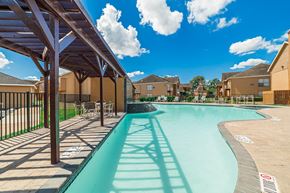 Houston apartment for rent - A swimming pool with a slide and a fence.