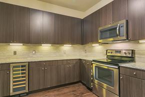 Irving townhouse for rent - a kitchen with dark wood cabinets and stainless steel appliances