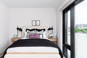 Washington apartment for rent - A bedroom with a large bed and a window overlooking a street.