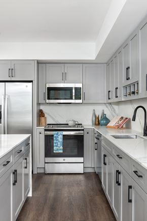 Washington apartment for rent - A modern kitchen with white cabinets and stainless steel appliances.