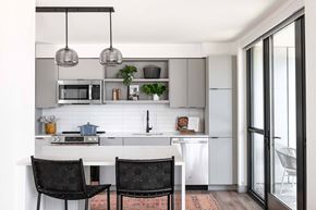 Washington apartment for rent - A modern kitchen with a white countertop and black chairs.