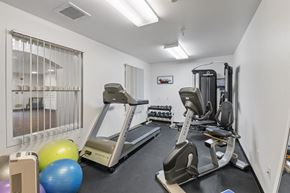 Garden City apartment for rent - two treadmills and other exercise equipment in a gym with a window