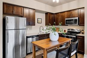 Missoula apartment for rent - A kitchen with a wooden table and chairs, a refrigerator, a microwave, and a stove at Brooklyn West Apartments, Missoula, MT, 59808