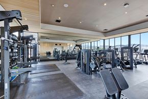 Missoula apartment for rent - A spacious gym with a variety of equipment and a large window overlooking the beach.