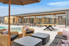 Missoula apartment for rent - A patio area with wicker furniture and a pool.