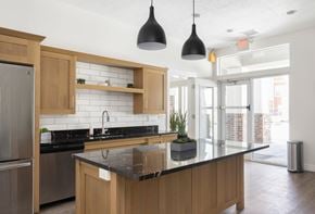 Vineyard apartment for rent - a kitchen with wooden cabinets and a large island with a black countertop at The Alloy at Geneva, Vineyard, 84058
