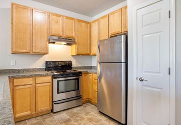 Missoula apartment for rent - A kitchen with wooden cabinets and a stainless steel refrigerator.