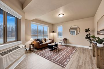 Missoula apartment for rent - A living room with a brown couch and a round mirror on the wall.
