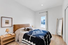 Missoula apartment for rent - A bedroom with a large bed and a wooden nightstand.