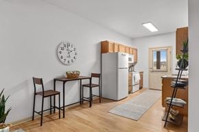 Billings townhouse for rent - A kitchen with a table and chairs and a clock on the wall at King West One Apartments, Montana, 59106.