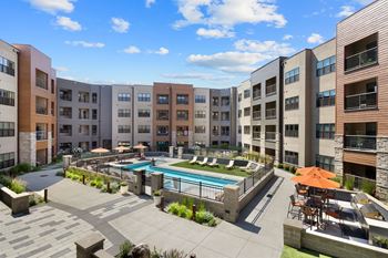 A large pool is in the middle of a building with apartments