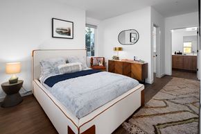 Bozeman apartment for rent - A bedroom with a large bed and a wooden dresser.