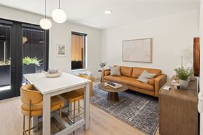 Bozeman apartment for rent - A modern living room with a white dining table and yellow chairs.