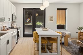Bozeman apartment for rent - A modern kitchen with a white table and yellow chairs.