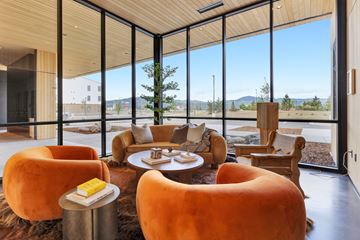 Missoula apartment for rent - A living room with orange chairs and a round table.
