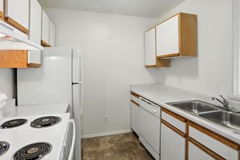 A kitchen with white appliances and wooden cabinets.