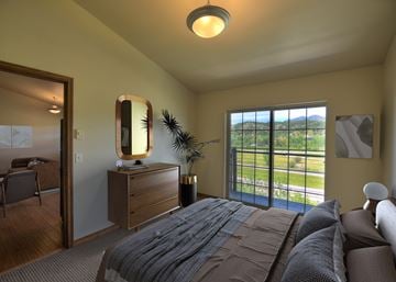 Bozeman apartment for rent - A bedroom with a large bed and a view of the outdoors through the window.