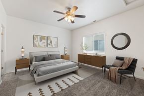 Meridian townhouse for rent - A bedroom with a bed, chair, and a rug. at Verraso Village Apartments, Meridian 83646
